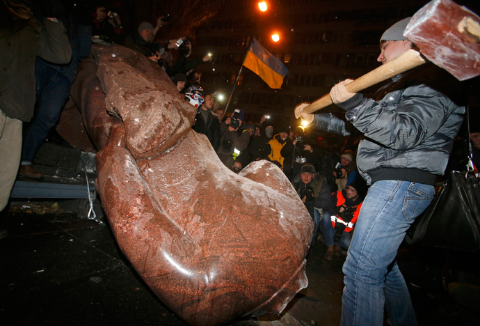 A man holds a sledgehammer as he smashes a statue of Soviet state founder Vladimir Lenin, which was toppled by protesters during a rally organized by supporters of EU integration in Kiev, December 8, 2013. (Reuters / Stoyan Nenov)